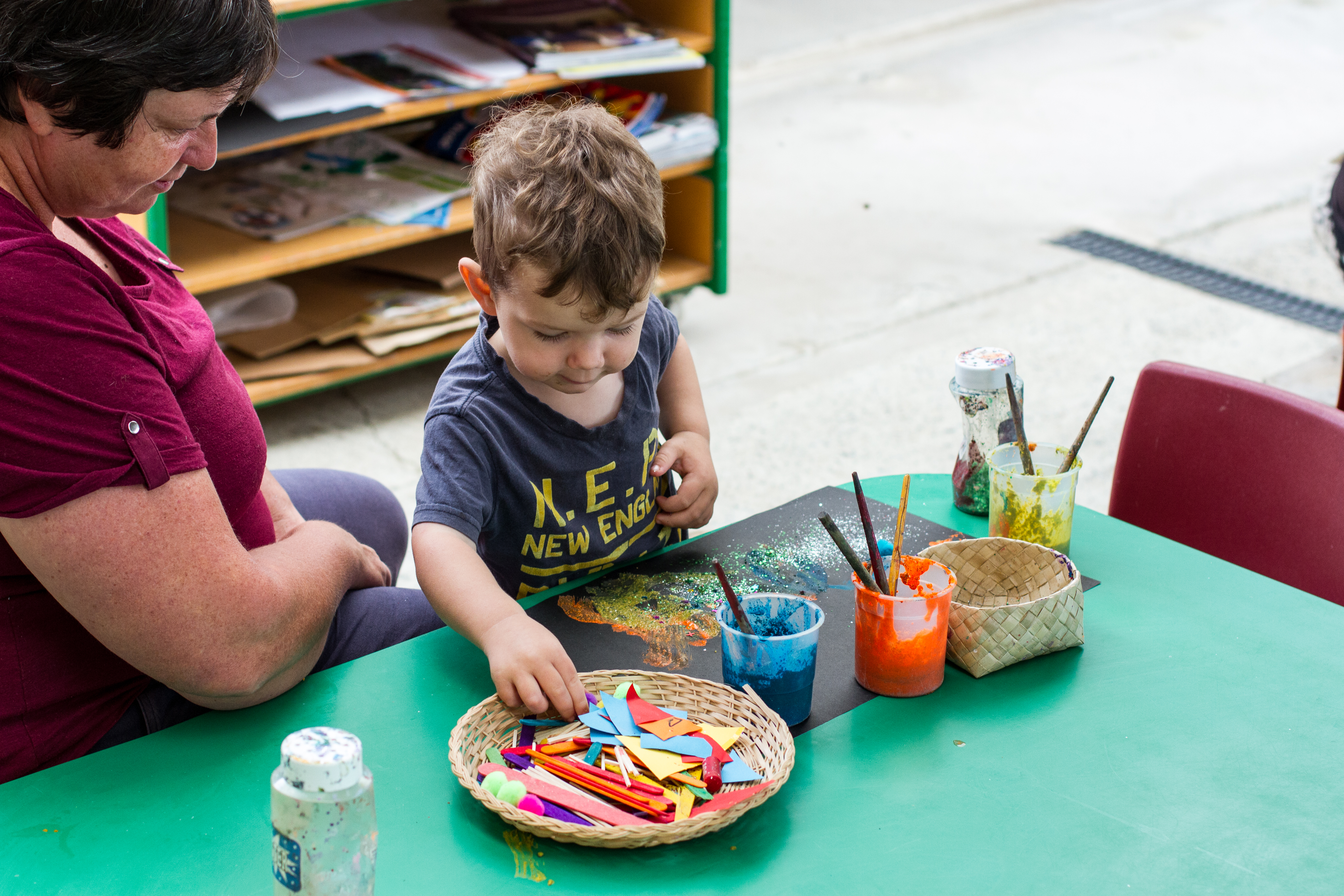 Te Pahu Preschooler making a picture with paint and strips of paper